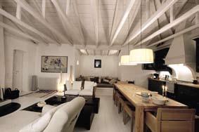 Традиционните елементи са преоблечени в модерен лукс - мебелите от дърво са с изчистен дизайн, а белите греди на тавана подчертават елегантната